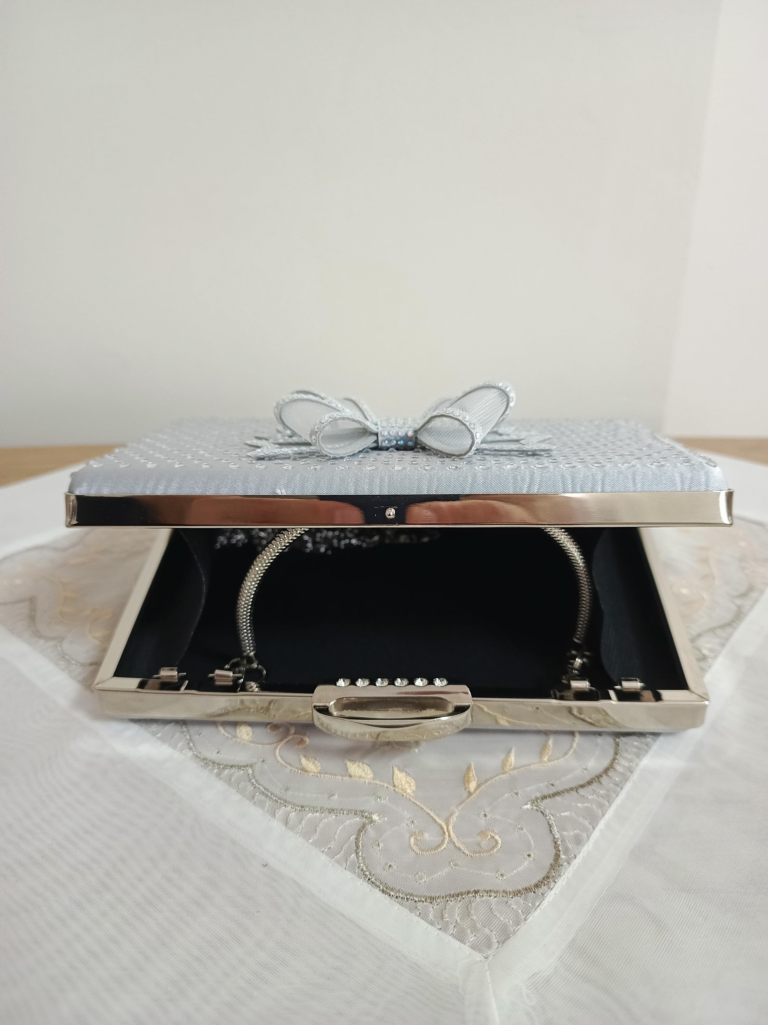 Silberne Abendclutch mit Schleifenverzierung
