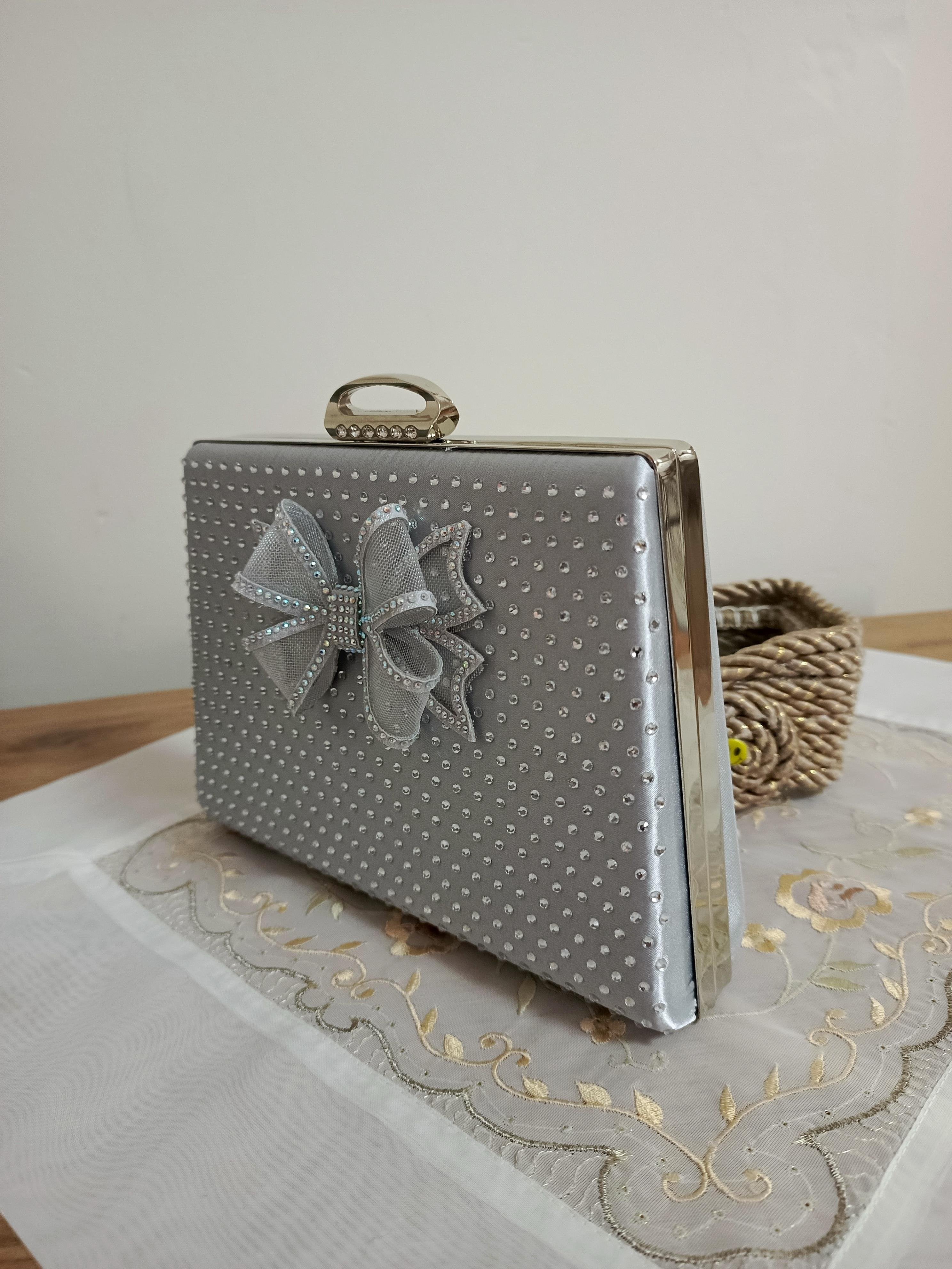 Silberne Abendclutch mit Schleifenverzierung