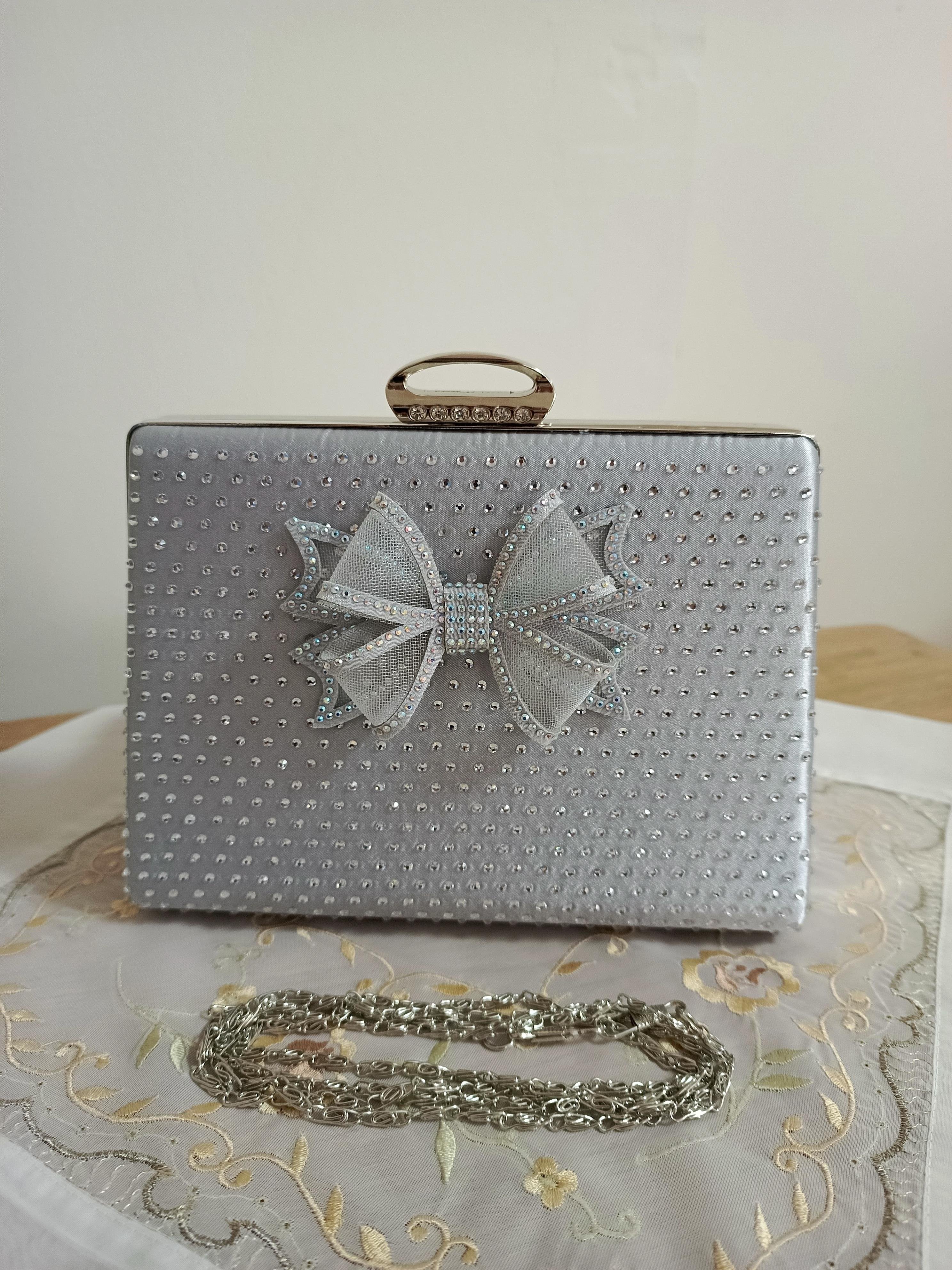Silberne Abendclutch mit Schleifenverzierung